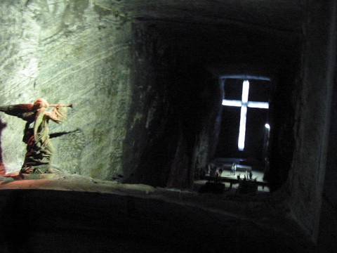 Ao longo da galeria de acesso encontram-se as esta?es do Via Crucis. Um anjo no coro com a trompete, anuncia a ressurrei??o de Jesus Cristo. Ao fundo o Altar da Catedral precedido pela grande Cruz.